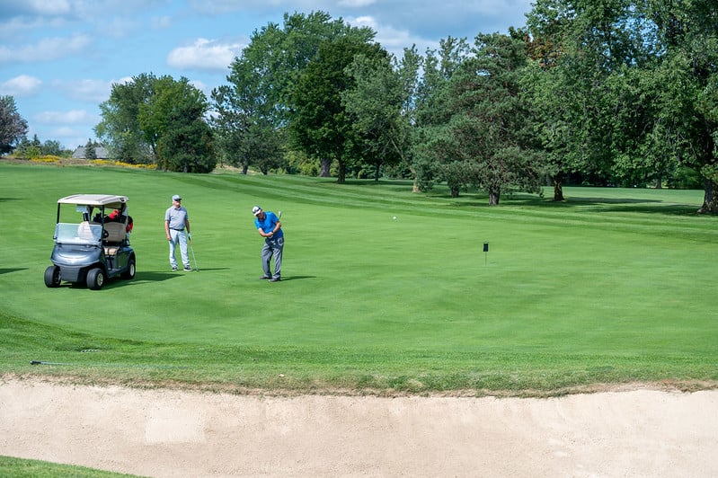 Two golfers teeing off at the 2023 Mayors Golf Classic